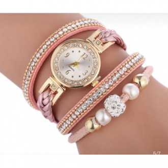 Zlaté hodinky s růžovým náramkem, ovinutým řemínkem